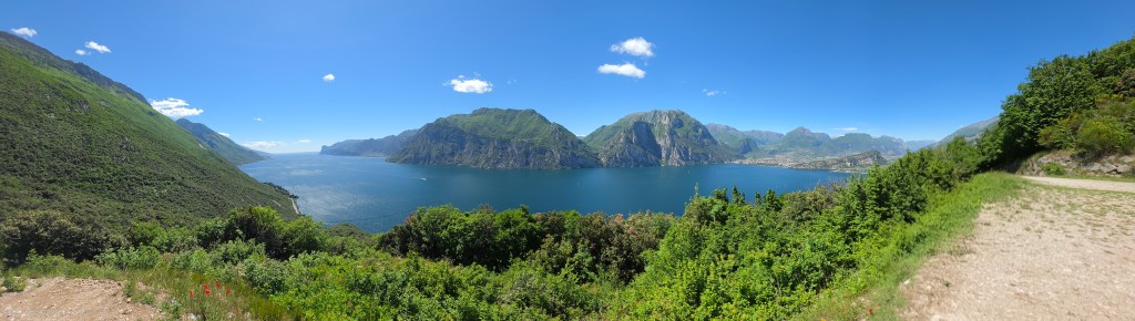 Panorama-Spot am oberen Busatte-Tempesta Wanderweg mit weitem Blick über den Gardasee, Berge, blaues Wasser und mediterrane Landschaft.