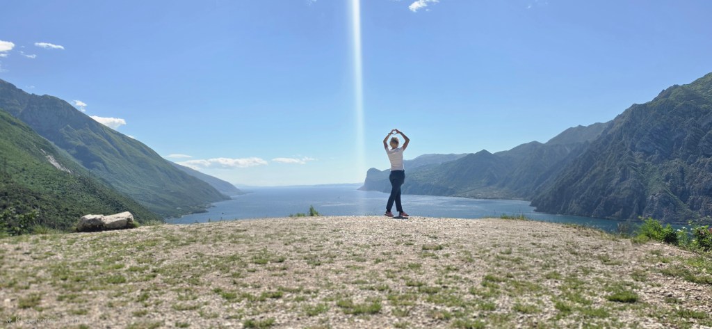 Panorama-Spot auf dem Busatte-Tempesta Wanderweg am Gardasee mit Wanderer, weitem Seeblick, Bergen und italienischer Outdoor-Atmosphäre.