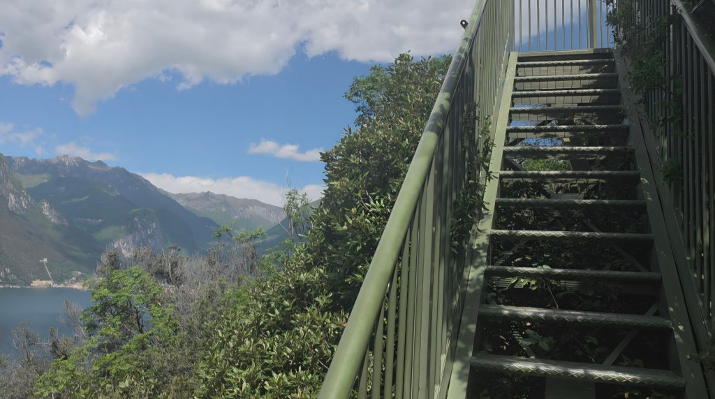 Steile Metalltreppe am Busatte-Tempesta Wanderweg oberhalb vom Gardasee mit Blick auf See, Berge und Panorama Richtung Torbole.